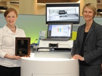Jessica Merlino, Tecan Product Manager, and Christie Dudenhoefer, HP Instrument Design Lead, accept the award